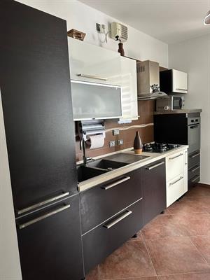 Cucina con elettrodomestici, tavolo e sedie