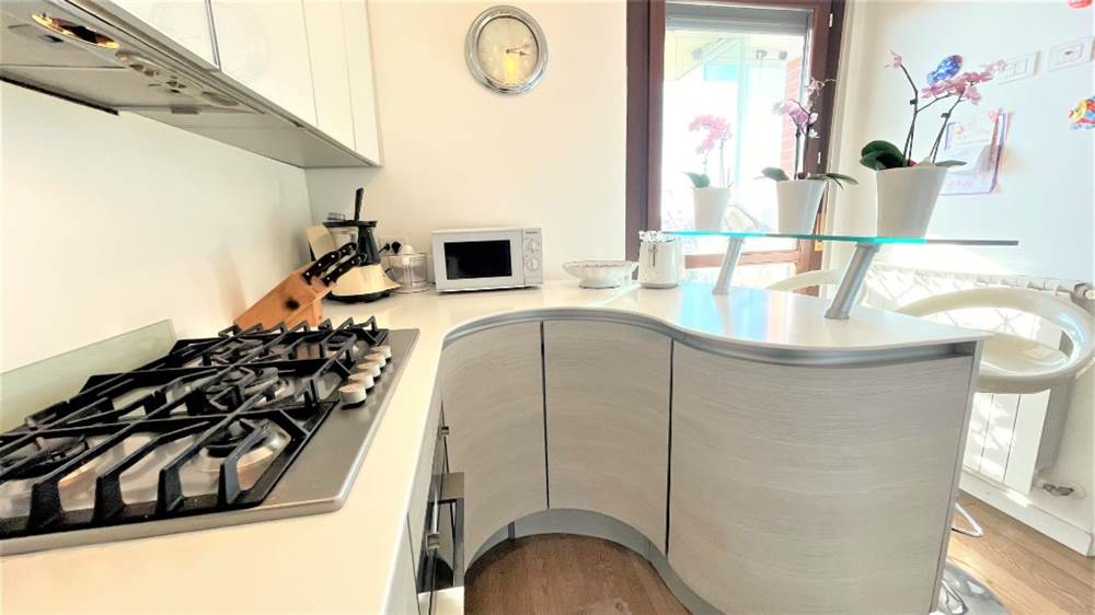 Cucina ad angolo con penisola completa con pensili in vetro